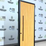 Puerta de alta seguridad de aluminio RPT Climatic 85. Cerco de aluminio lacado en negro mate y hoja de aluminio acabado cipres.